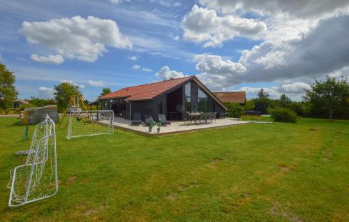 a house with a playground in a yard at Cozy Home In Væggerløse With Wifi in Marielyst