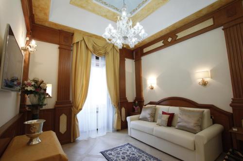 ein Wohnzimmer mit einem Sofa und einem Kronleuchter in der Unterkunft Rome Imperial Crown in Rom