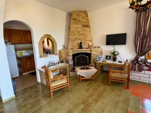 a living room with a table and a fireplace at Papadiokampos Maissonete in Roússa Límni