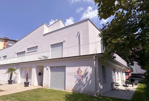 a white building with a balcony on the side of it at Grazora Living Apartments in Graz