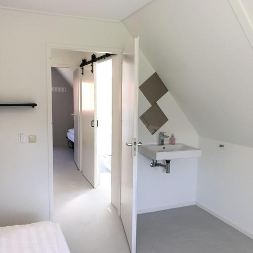 a white room with a sink and a bathroom at De Kastanje 5-persoons met overdekte lounge en hottub, barrelsauna, stoomsauna, ligbad, sunshower, wifi in Lievelde
