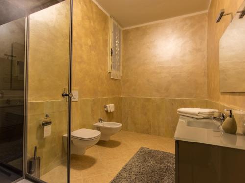 a bathroom with a toilet and a glass shower at LM House in Lonato del Garda