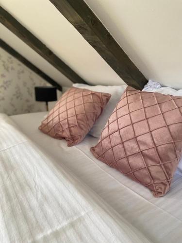 a bed with two pink pillows on it at Adria Nord Chalets in Žabljak
