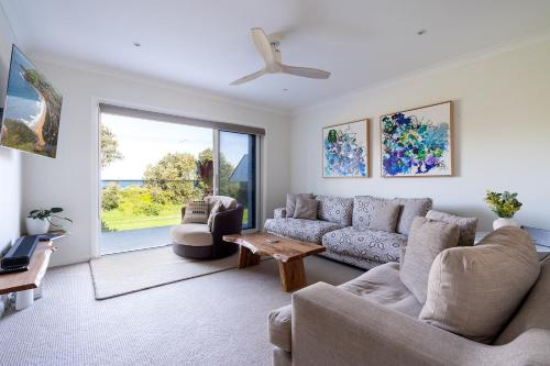 a living room with a couch and a table at Werri Big Beach House in Gerringong