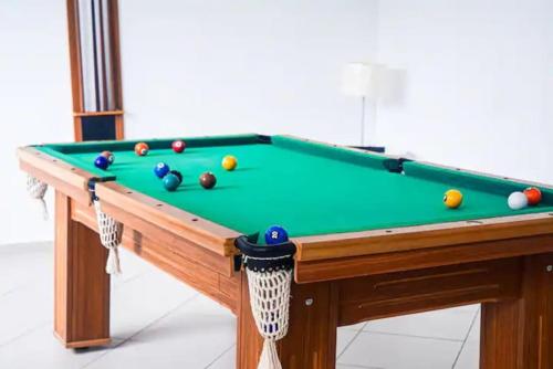 einen Billardtisch mit Bällen darüber in der Unterkunft Luxuoso AP no Martim Praia Clube - Martim de Sá in Caraguatatuba