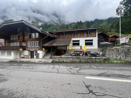 a building on the side of a road next to a mountain at Gadmen Alpenrose, Switzerland in Gadmen