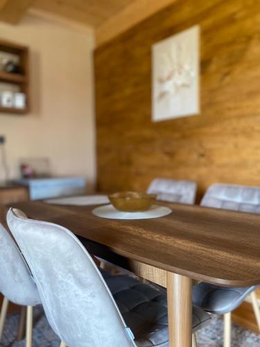 a wooden table with chairs and a bowl on it at Adria Nord Chalets in Žabljak