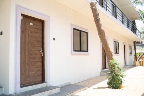 a building with a wooden door on the side of it at Nosso Amor Stay in Siolim