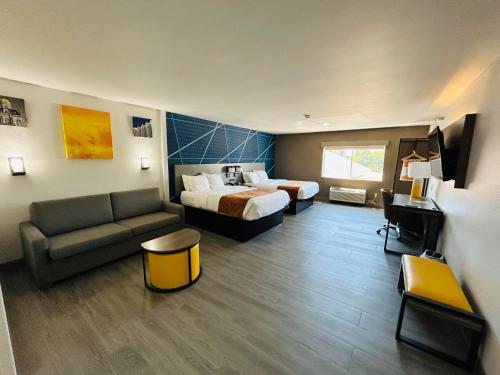 a hotel room with two beds and a couch at Comfort Suites Terre Haute University Area in Terre Haute