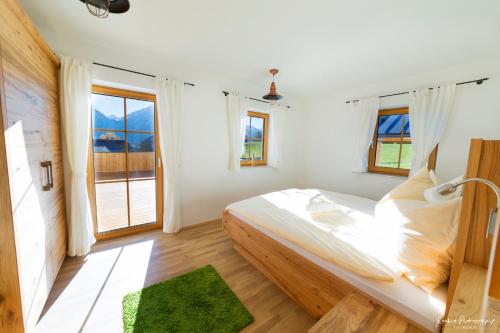 a bedroom with a large bed and a large window at Feriengut Linortner in St. Wolfgang