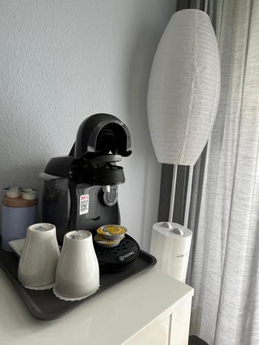 a coffee maker and two cups on a shelf at Hotel Markgraf in Bad Bellingen