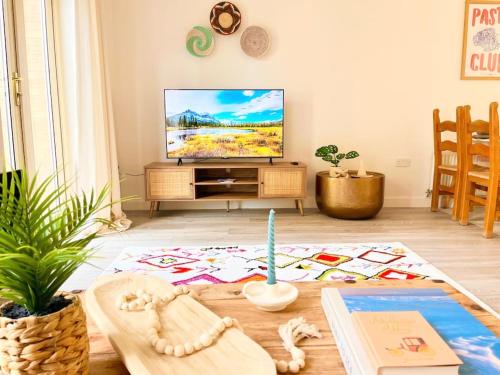 a living room with a television and a table at Artistic, Bright & Spacious 3 Bedroom Home in Kirkstall