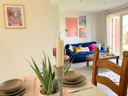 a living room with a table and a blue couch at Artistic, Bright & Spacious 3 Bedroom Home in Kirkstall
