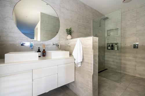 Un baño con dos lavabos y un espejo. en Werri Big Beach House, en Gerringong