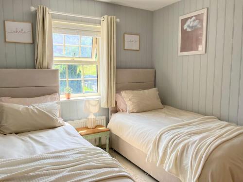 a bedroom with two beds and a window at Artistic, Bright & Spacious 3 Bedroom Home in Kirkstall