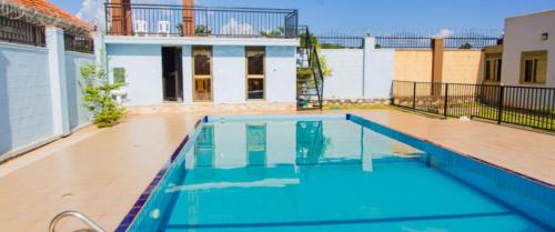 a large swimming pool in the middle of a house at Blanket Suites in Kabubu