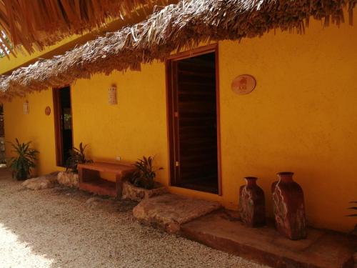 a yellow house with vases sitting outside of it at Suites de Piedra y Colores en Chichen Itzá in Pisté