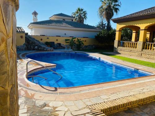 a large swimming pool in front of a house at La Almadraba in Chiclana de la Frontera