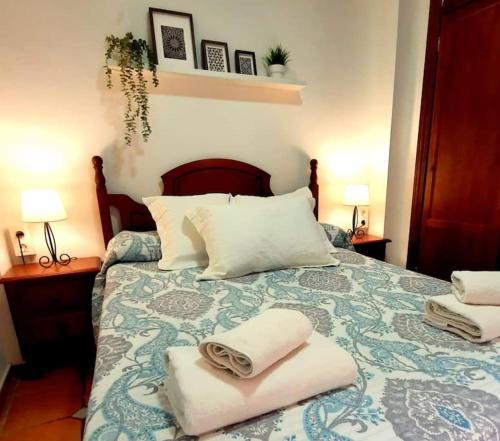 a bedroom with a bed with towels on it at Alhambra Catedral Centro in Granada