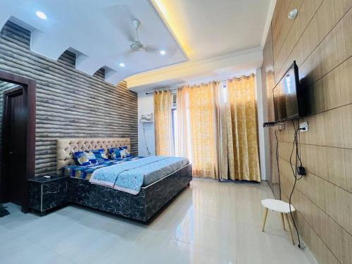 a bedroom with a bed and a television in it at ANAisha mansION Near Helipad Rajpur Road shastradhara Hill View in Dehradun