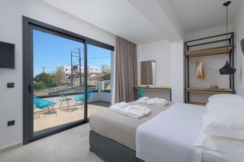 a bedroom with a bed and a balcony with a view at Villa Lambis Athena in Líndos