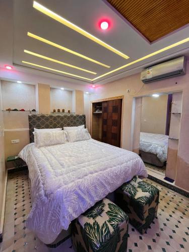 a bedroom with a large bed with two ottomans at Gite ECOPARADIS in Madagh