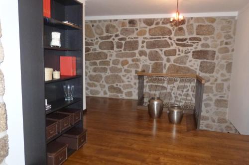 a fireplace in a room with a stone wall at Quinta do Correia in Cabeceiras de Basto