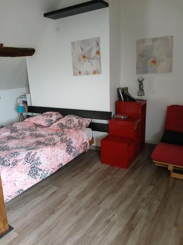 une chambre avec un lit et une chaise rouge dans l'établissement ha-ha, à Villegouin