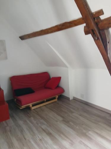 - un canapé rouge dans l'angle d'une pièce dans l'établissement ha-ha, à Villegouin