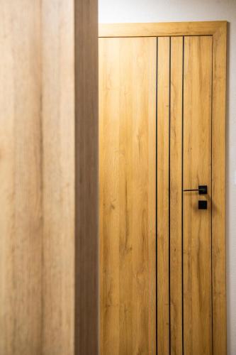 a wooden door next to a wooden wall at Apartamenty Balijskie in Gliwice