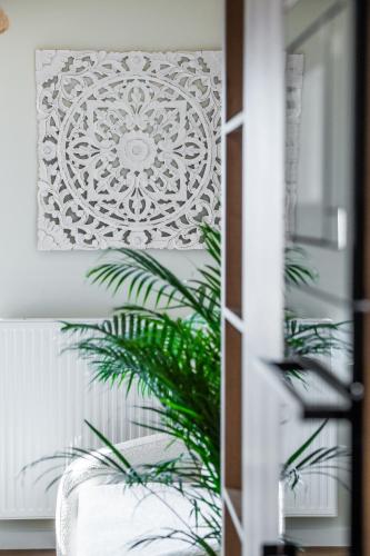 a living room with a plant in front of a door at Apartamenty Balijskie in Gliwice