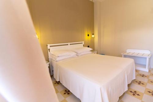 a bedroom with a white bed and a tiled floor at Villa Rosa Antico Dimora Storica in Otranto
