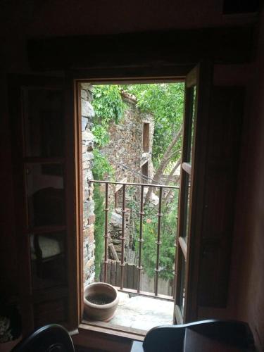 an open window with a view of a stone building at Hotel Rural La Fuente in Patones