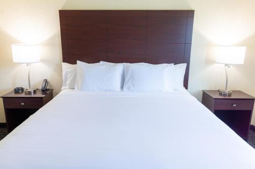 a large bed in a hotel room with two lamps at Cobblestone Inn & Suites - Winters in Winters