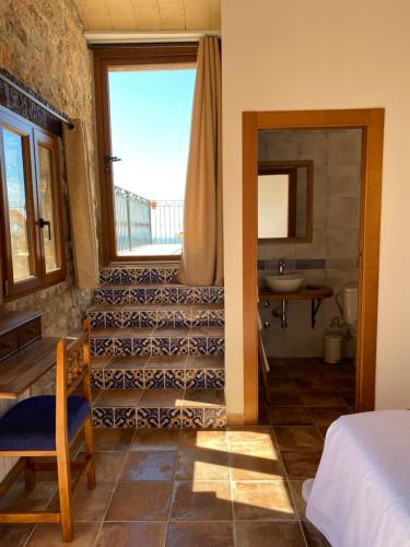 a room with a bathroom with a sink and a bed at La Cueva de Miravet - villa de lujo en la cima de la montaña con vistas al mar in Cabanes
