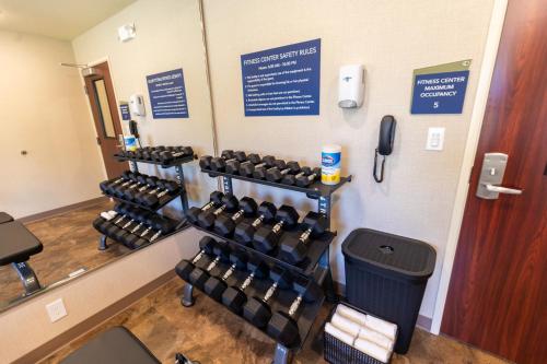 a gym with rows of dumbbells on the wall at Cobblestone Inn & Suites - Winters in Winters
