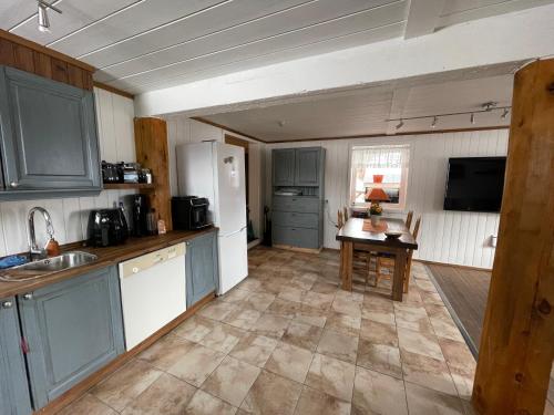 a kitchen with blue cabinets and a table in it at Hyggelig og velutstyrt leilighet i Lom sentrum in Lom
