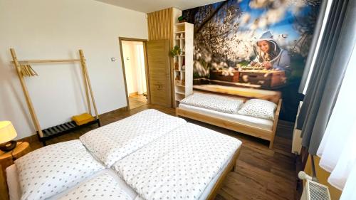 a room with two beds and a painting on the wall at Apartmány SVRČINKY in Liptovský Mikuláš