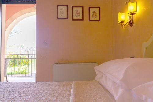 a bedroom with a white bed and a window at Villa Rosa Antico Dimora Storica in Otranto