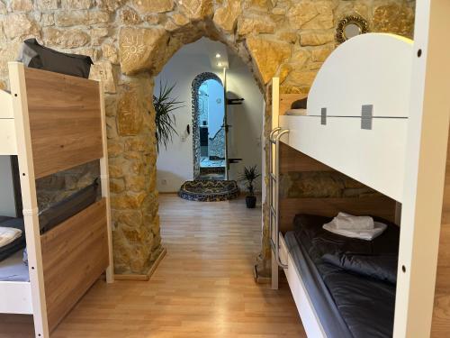 a room with bunk beds and a stone wall at Hilde Apartments in Rheinhausen