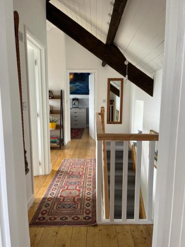 a hallway with a table and a rug in a room at Pier Cottage with private water access to Colla Pier in Schull