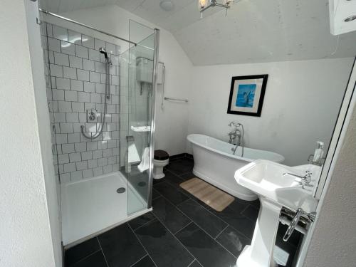 a bathroom with a shower and a tub and a sink at Pier Cottage with private water access to Colla Pier in Schull