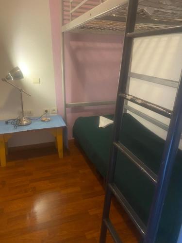 a bedroom with a bunk bed and a lamp and a table at Maisonnette dans village vacances canapé convertible , chambre 1 lit et mezzanine ,draps en plus in Cassen