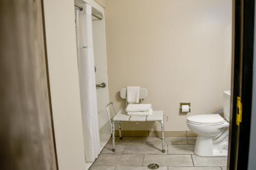 a bathroom with a toilet and a table with towels at Baymont by Wyndham O'Fallon St. Louis Area in O'Fallon