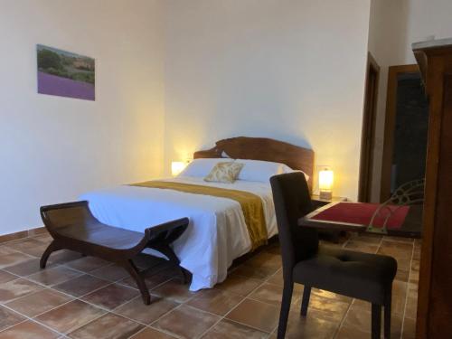 a bedroom with a bed and a chair and a desk at La Cueva de Miravet - villa de lujo en la cima de la montaña con vistas al mar in Cabanes
