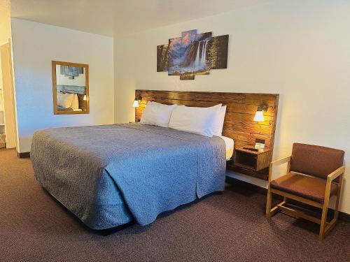 a hotel room with a bed and a chair at Red Bear Inn in Ennis
