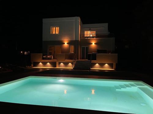 a swimming pool in front of a house at night at Villa dei Mori in Capitana