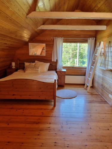 a bedroom in a log cabin with a bed and a ladder at Villa and cottage by the sea in Sunnanberg