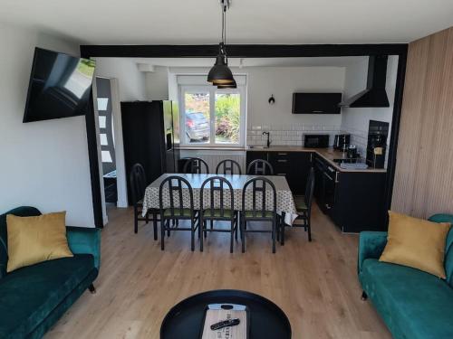 un salon avec une table et des chaises et une cuisine dans l'établissement Les brumes du Mont Saint Michel, à Beauvoir