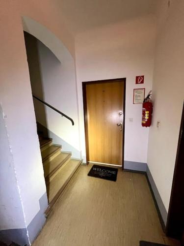 a hallway with a door and stairs and a fire extinguisher at Mini Flat in Graz